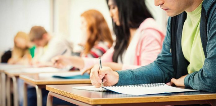 Young students writing notes in classroom